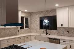 Kitchen with white cabinetry, contemporary tile backsplash, and sleek appliances for a modern look.