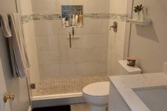 Clean, contemporary bathroom featuring a tiled shower, white vanity, and minimal decor for a fresh look.