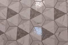Close-up of a geometric tile floor showcasing gray and white patterns installed by Grapme Tile Works.