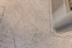 Close-up of marble tile flooring in a home, showcasing professional installation by Grapme Tile Works Corp.