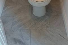 Bathroom featuring newly installed tile flooring and a clean, modern toilet by Grapme Tile Works Corp.