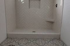 Elegant bathroom with decorative wall and floor tiles, showcasing professional tile work by Grapme Tile Works Corp.