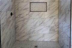 Luxury marble bathroom shower with sleek tile pattern and natural light.