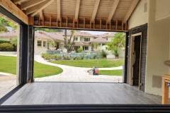 Spacious outdoor patio with a view of a lush garden and neighboring houses, showcasing quality tile work.