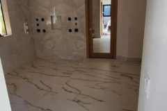 Interior featuring luxurious marble tile flooring and wall accents, showcasing high-quality craftsmanship by Grapme Tile Works Corp.