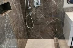 Luxurious marble tiled shower with contemporary fixtures and sleek design.
