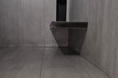 Interior view showcasing sleek gray wall and floor tiles with a built-in bench, highlighting quality tile installation by Grapme Tile Works.