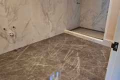 Luxurious marble bathroom with sleek wall and floor tiles, showcasing high-quality craftsmanship by Grapme Tile Works.