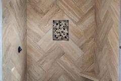 Elegant shower design featuring large wall tiles, a pebble floor, and a built-in niche for toiletries.