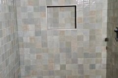 Beautifully tiled bathroom shower with niche and window, showcasing expert tile work by Grapme Tile Works Corp.