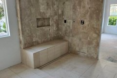 Tile wall renovation with a built-in bench in a contemporary interior space.