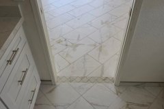A stylish marble tile floor in a contemporary home, showcasing quality craftsmanship by Grapme Tile Works Corp.