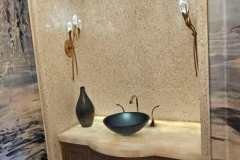 Stylish bathroom niche featuring textured tiles, wall sconces, and a vessel sink for a sophisticated look.