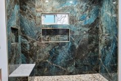 Beautiful blue marble shower with built-in shelves, showcasing luxurious bathroom tiling and craftsmanship.