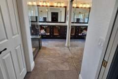 Elegant bathroom featuring tile flooring, a large mirror, and contemporary lighting, showcasing Grapme Tile Works' craftsmanship.