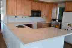 Beautiful kitchen featuring a marble-look granite countertop, wooden cabinets, and modern appliances for a stylish home.