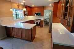 Spacious kitchen featuring wooden cabinetry, white countertops, and contemporary appliances, ideal for elegant and functional home cooking spaces.
