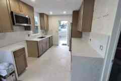 Kitchen interior with natural light, wooden cabinetry, and spacious layout.