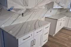 Beautiful white kitchen with marble countertops and modern cabinetry design.