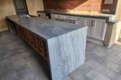 A contemporary kitchen featuring a gray stone island with a polished finish, perfect for cooking and socializing.