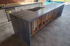 Custom-built concrete kitchen island with wooden framing, perfect for modern outdoor or indoor kitchens.