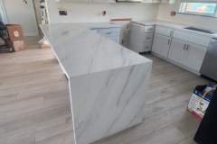 Stylish white marble kitchen island enhances contemporary kitchen aesthetics and functionality.