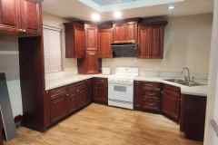 Kitchen with rich wooden cabinets, white stove, and modern design.
