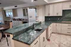 Modern kitchen featuring green marble countertops and custom cabinetry by Grapme Tile Works.