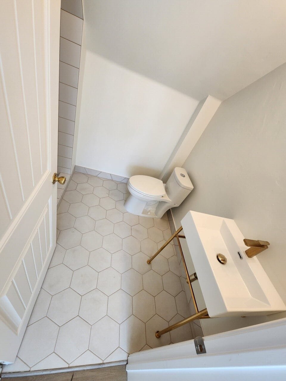 Bathroom tile installation with hexagonal tiles and elegant fixtures.