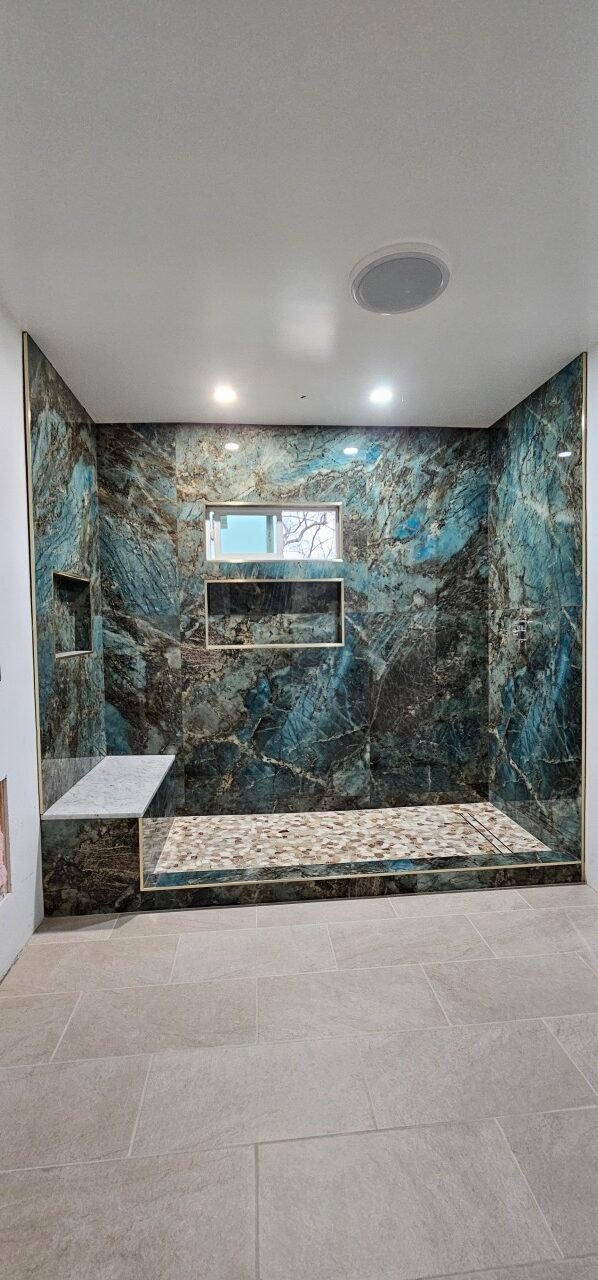 Blue marble shower with built-in shelves and modern bathroom design.